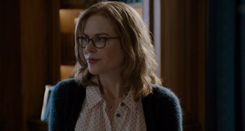 Movie still from “The Upside” (2017), directed by Neil Burger – A person wearing glasses and a sweater; Close Up shot, Over the shoulder angle