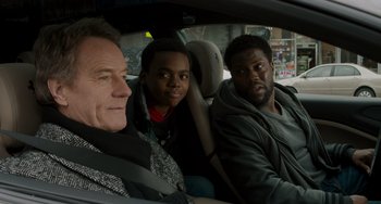 Movie still from “The Upside” (2017), directed by Neil Burger – A man and two men sitting in the back of a car; Close Up shot, Over the shoulder angle