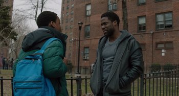 Movie still from “The Upside” (2017), directed by Neil Burger – Two men talking in front of a brick building; Medium shot, Over the shoulder angle