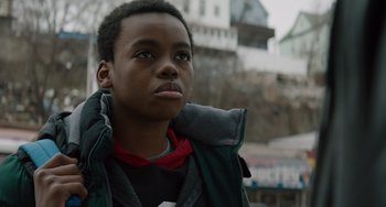 Movie still from “The Upside” (2017), directed by Neil Burger – A young man is looking into the distance while wearing a jacket; Close Up shot, Low angle