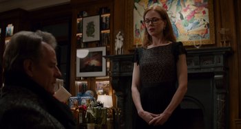 Movie still from “The Upside” (2017), directed by Neil Burger – A woman standing in front of a wall with paintings; Medium shot, Over the shoulder angle