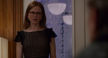 Movie still from “The Upside” (2017), directed by Neil Burger – A woman wearing glasses and a black and white dress; Medium shot, Over the shoulder angle