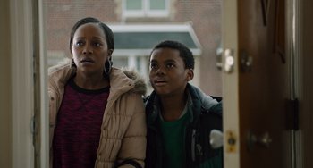 Movie still from “The Upside” (2017), directed by Neil Burger – A woman standing next to a young boy in front of a building; Medium shot, Over the shoulder angle