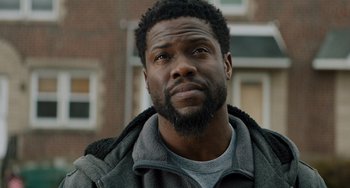Movie still from “The Upside” (2017), directed by Neil Burger – A person wearing a jacket; Close Up shot, Over the shoulder angle