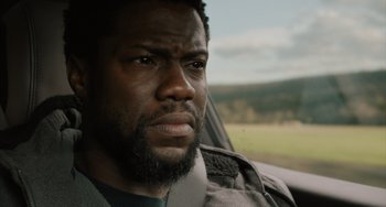 Movie still from “The Upside” (2017), directed by Neil Burger – A person in a car looking at the camera; Close Up shot, Over the shoulder angle