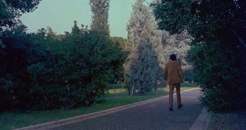 Movie still from “Four Times That Night” (1971), directed by Mario Bava – A man in a suit walking down the street; Extreme Wide shot, Low angle