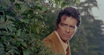 Movie still from “Four Times That Night” (1971), directed by Mario Bava – A person standing near a tree; Close Up shot, Over the shoulder angle
