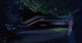 Movie still from “Four Times That Night” (1971), directed by Mario Bava – A night scene of a street with a tree in the background; Extreme Wide shot, High angle
