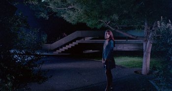 Movie still from “Four Times That Night” (1971), directed by Mario Bava – A woman standing in the middle of the street at night; Wide shot, Low angle