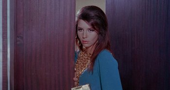 Movie still from “Four Times That Night” (1971), directed by Mario Bava – A woman in a blue dress and gold jewelry; Close Up shot, High angle