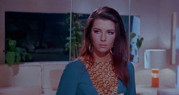Movie still from “Four Times That Night” (1971), directed by Mario Bava – A woman with long hair wearing a blue dress; Close Up shot, Low angle