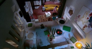 Movie still from “Four Times That Night” (1971), directed by Mario Bava – An overhead view of a room with a woman in the background; Extreme Wide shot, Overhead angle
