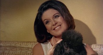 Movie still from “Four Times That Night” (1971), directed by Mario Bava – A person with a dog; Close Up shot, Low angle