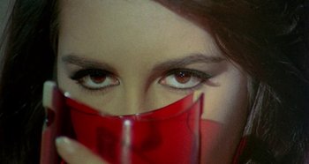 Movie still from “Four Times That Night” (1971), directed by Mario Bava – A person holding a glass of wine; Extreme Close Up shot, High angle