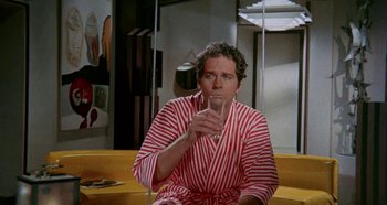 Movie still from “Four Times That Night” (1971), directed by Mario Bava – A man in a robe drinking a glass of wine; Medium shot, High angle