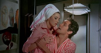 Movie still from “Four Times That Night” (1971), directed by Mario Bava – A man and a woman in striped shirts and a head scarf; Medium shot, Low angle