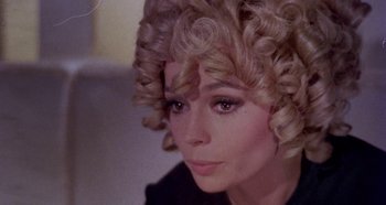 Movie still from “Four Times That Night” (1971), directed by Mario Bava – A person wearing a wig; Close Up shot, Over the shoulder angle