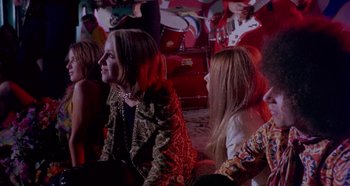 Movie still from “Four Times That Night” (1971), directed by Mario Bava – A group of people sitting in a room; Medium shot, Low angle