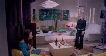 Movie still from “Four Times That Night” (1971), directed by Mario Bava – Two women are sitting in a living room; Wide shot, High angle