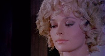 Movie still from “Four Times That Night” (1971), directed by Mario Bava – A woman's face with blonde hair; Close Up shot, Over the shoulder angle