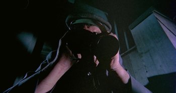 Movie still from “Four Times That Night” (1971), directed by Mario Bava – A person taking a picture with a camera; Extreme Close Up shot, Overhead angle