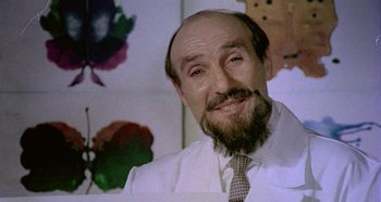 Movie still from “Four Times That Night” (1971), directed by Mario Bava – A man with a goatee and a beard wearing a tie; Close Up shot, Low angle