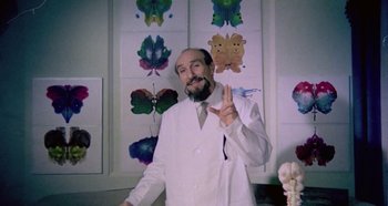 Movie still from “Four Times That Night” (1971), directed by Mario Bava – A man in a white lab coat giving a peace sign; Medium shot, Low angle