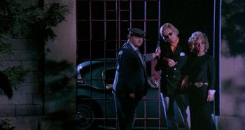 Movie still from “Four Times That Night” (1971), directed by Mario Bava – A man and a woman standing next to each other holding guns; Wide shot, Low angle