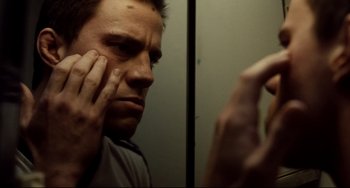 Movie still from “Foxcatcher” (2014), directed by Bennett Miller – A man looking in the mirror while putting something on his face; Close Up shot, Low angle