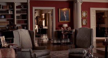 Movie still from “Foxcatcher” (2014), directed by Bennett Miller – A living room with a picture of a man on the wall; Wide shot, High angle