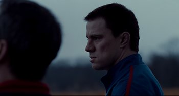 Movie still from “Foxcatcher” (2014), directed by Bennett Miller – A person wearing a blue jacket; Close Up shot, Over the shoulder angle