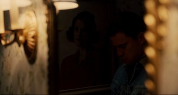Movie still from “Foxcatcher” (2014), directed by Bennett Miller – A man sitting in front of a woman's reflection in a mirror; Close Up shot, Over the shoulder angle