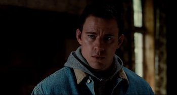 Movie still from “Foxcatcher” (2014), directed by Bennett Miller – A man in a hooded jacket looking at the camera; Close Up shot, High angle