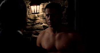 Movie still from “Foxcatcher” (2014), directed by Bennett Miller – A shirtless man in front of a stone wall; Close Up shot, Over the shoulder angle