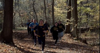 Movie still from “Foxcatcher” (2014), directed by Bennett Miller – A group of people are running through the woods; Wide shot, High angle