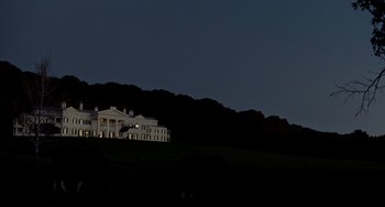 Movie still from “Foxcatcher” (2014), directed by Bennett Miller – A large white building sitting on top of a hill at night; Extreme Wide shot, Low angle