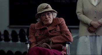 Movie still from “Foxcatcher” (2014), directed by Bennett Miller – An older woman sitting in a chair wearing a hat; Medium shot, Over the shoulder angle