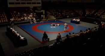 Movie still from “Foxcatcher” (2014), directed by Bennett Miller – A wrestling match in progress in an indoor arena; Extreme Wide shot, High angle