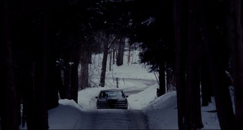 Movie still from “Foxcatcher” (2014), directed by Bennett Miller – A car driving down a snow covered road through the woods; Extreme Wide shot, High angle