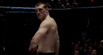 Movie still from “Foxcatcher” (2014), directed by Bennett Miller – A man standing in front of a crowd in a boxing ring; Medium shot, Low angle