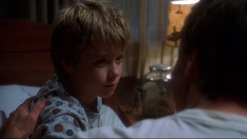 Movie still from “Frailty” (2001), directed by Bill Paxton – A young boy sitting in front of an older man; Close Up shot, Over the shoulder angle