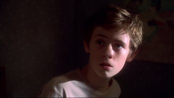Movie still from “Frailty” (2001), directed by Bill Paxton – A young boy is looking into the camera; Close Up shot, Low angle