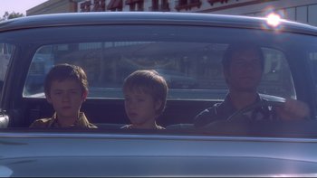 Movie still from “Frailty” (2001), directed by Bill Paxton – Three people in a car looking out of the window; Medium shot, Low angle
