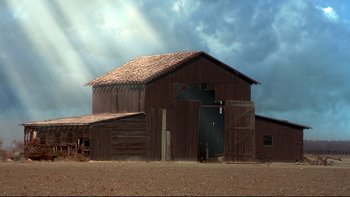 Movie still from “Frailty” (2001), directed by Bill Paxton – An old wooden barn with a sky background; Extreme Wide shot, Low angle