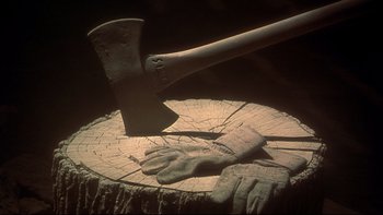 Movie still from “Frailty” (2001), directed by Bill Paxton – An ax and a pair of work gloves on a stump; Extreme Close Up shot, Low angle