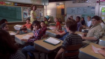 Movie still from “Frailty” (2001), directed by Bill Paxton – A group of children sitting at desks in a classroom; Medium shot, Over the shoulder angle