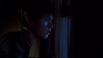 Movie still from “Frailty” (2001), directed by Bill Paxton – A young boy looking out of a window at night; Close Up shot, Low angle