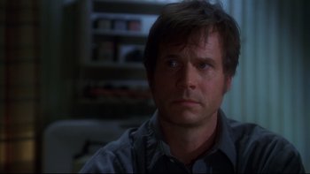 Movie still from “Frailty” (2001), directed by Bill Paxton – A person wearing a gray shirt; Close Up shot, Over the shoulder angle