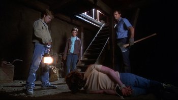Movie still from “Frailty” (2001), directed by Bill Paxton – A group of men standing around a woman laying on the ground; Wide shot, Low angle