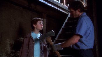 Movie still from “Frailty” (2001), directed by Bill Paxton – A man holding an axe talking to a young boy; Medium shot, Low angle